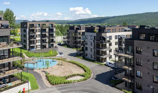 Overbilde av 7 leilighetsbygg med grøntområde i midten.